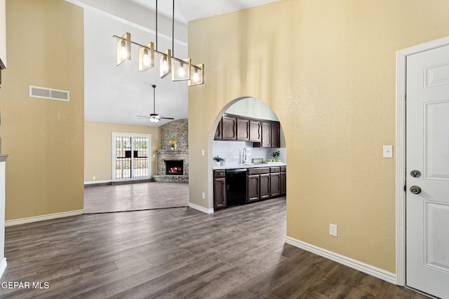 5261 Roger Maris Dr, El Paso, TX 79934 - unfurnished living room with high vaulted ceiling, a fireplace, dark wood-style floors, ceiling fan, and baseboards