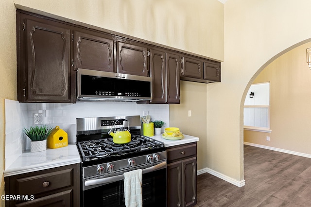 5261 Roger Maris Dr, El Paso, TX 79934 - kitchen featuring appliances with stainless steel finishes, arched walkways, dark brown cabinets, and light countertops