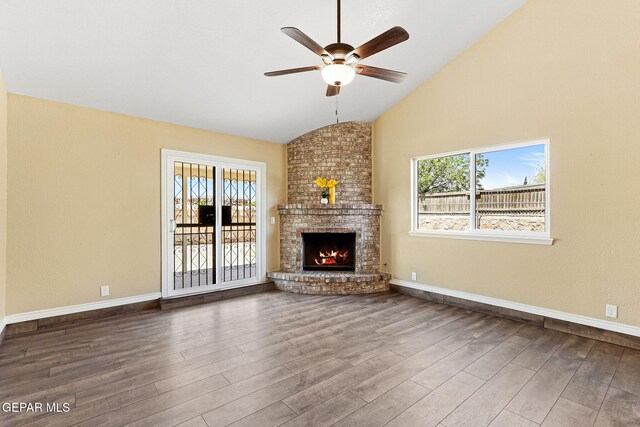 5261 Roger Maris Dr, El Paso, TX 79934 - unfurnished living room featuring lofted ceiling, ceiling fan, wood finished floors, healthy amount of natural light, and a brick fireplace