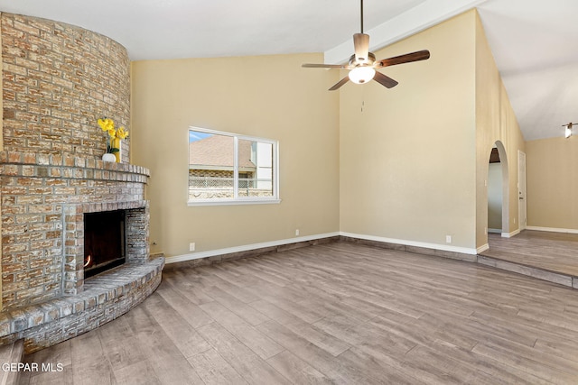 5261 Roger Maris Dr, El Paso, TX 79934 - unfurnished living room with high vaulted ceiling, a brick fireplace, a ceiling fan, wood finished floors, and baseboards