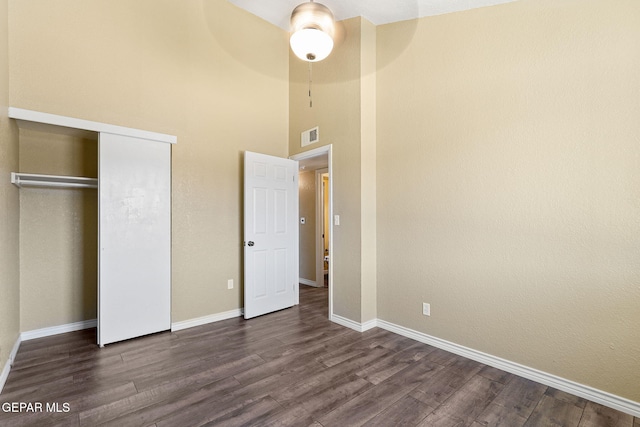 5261 Roger Maris Dr, El Paso, TX 79934 - unfurnished bedroom featuring dark wood finished floors, baseboards, a high ceiling, and a closet