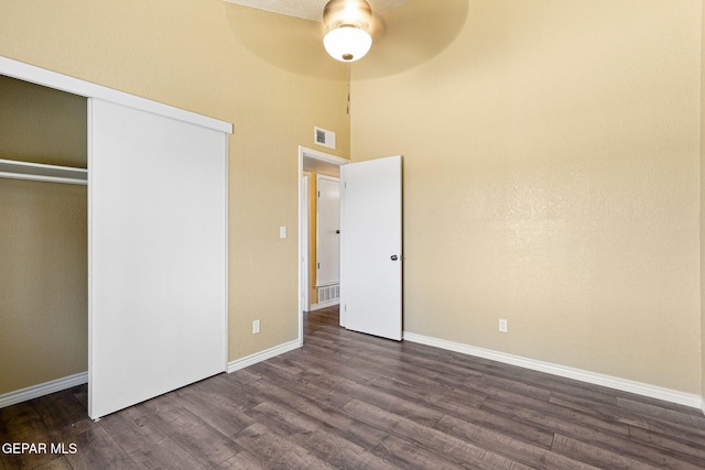 5261 Roger Maris Dr, El Paso, TX 79934 - unfurnished bedroom featuring dark wood-style floors, baseboards, a towering ceiling, a closet, and a ceiling fan
