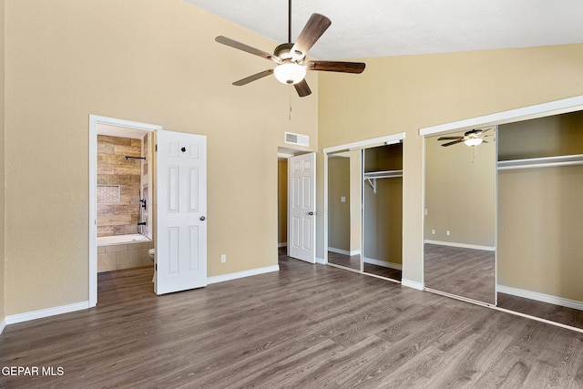 5261 Roger Maris Dr, El Paso, TX 79934 - unfurnished bedroom featuring two closets, dark wood finished floors, high vaulted ceiling, baseboards, and ensuite bathroom