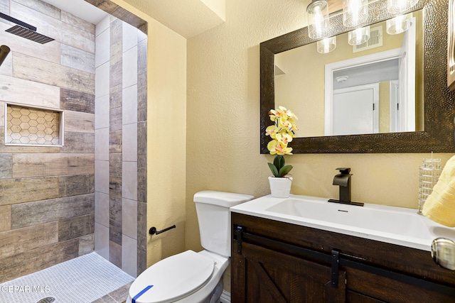 5261 Roger Maris Dr, El Paso, TX 79934 - full bath featuring toilet, vanity, a textured wall, and tiled shower