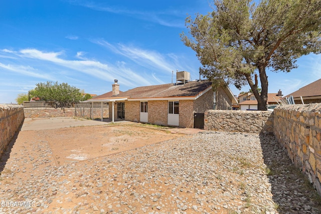 5261 Roger Maris Dr, El Paso, TX 79934 - rear view of house featuring a fenced backyard, a patio area, a chimney, central AC, and brick siding