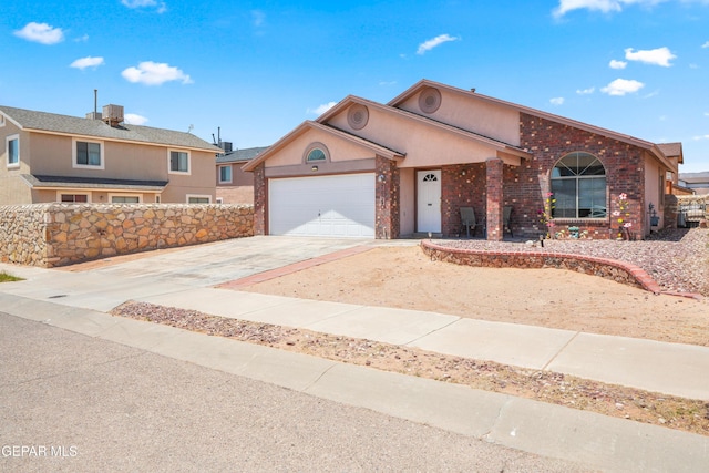7009 Falling Leaf Cir, El Paso, TX 79934 - view of front facade featuring a garage, concrete driveway, brick siding, and stucco siding