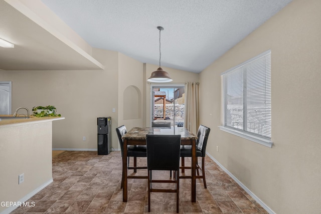 7009 Falling Leaf Cir, El Paso, TX 79934 - dining area featuring stone finish flooring, a textured ceiling, baseboards, and lofted ceiling