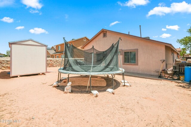 7009 Falling Leaf Cir, El Paso, TX 79934 - back of property with a trampoline and stucco siding