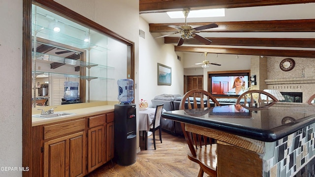 492 Country Oaks Dr, El Paso, TX 79932 - kitchen featuring beam ceiling, open floor plan, a sink, a ceiling fan, and a fireplace