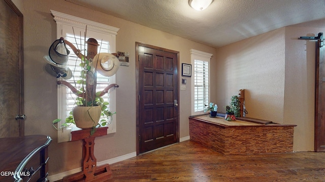 492 Country Oaks Dr, El Paso, TX 79932 - entrance foyer with wood finished floors, a barn door, a textured ceiling, and baseboards