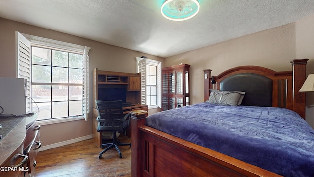 492 Country Oaks Dr, El Paso, TX 79932 - bedroom with wood finished floors, baseboards, and a textured ceiling