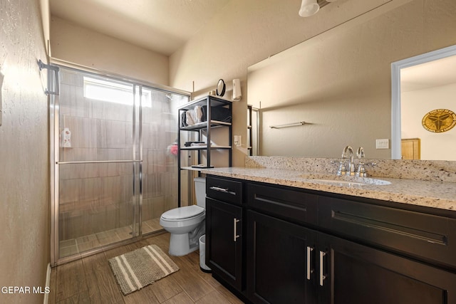 12805 Epsom Dr, Horizon City, TX 79928 - full bath with toilet, vanity, a shower stall, and wood finished floors