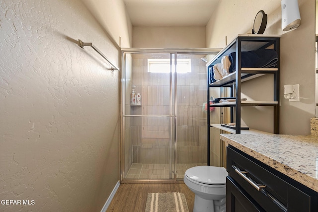 12805 Epsom Dr, Horizon City, TX 79928 - full bathroom featuring toilet, a shower stall, wood finished floors, vanity, and a textured wall