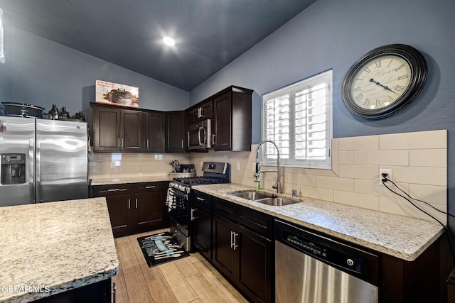 12805 Epsom Dr, Horizon City, TX 79928 - kitchen featuring appliances with stainless steel finishes, a sink, tasteful backsplash, vaulted ceiling, and light wood finished floors