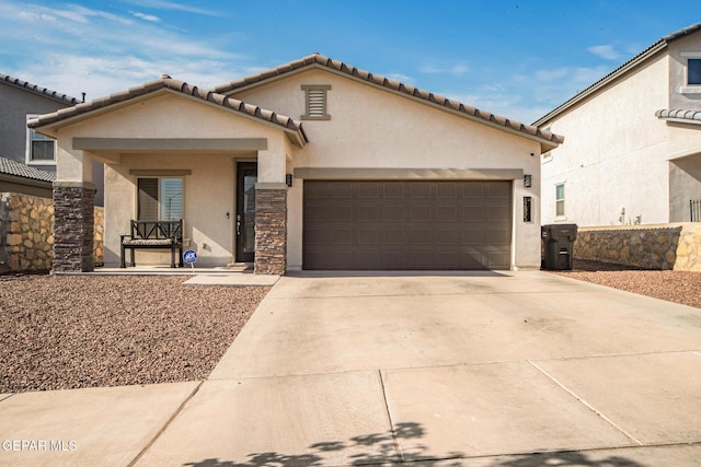12805 Epsom Dr, Horizon City, TX 79928 - mediterranean / spanish-style house with stucco siding, an attached garage, driveway, stone siding, and a tiled roof