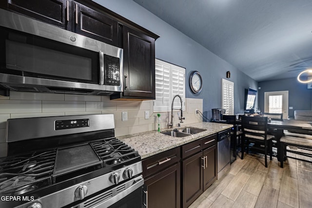 12805 Epsom Dr, Horizon City, TX 79928 - kitchen with stainless steel appliances, a sink, light stone countertops, decorative backsplash, and light wood finished floors