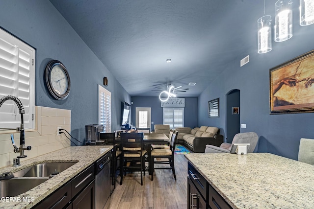 12805 Epsom Dr, Horizon City, TX 79928 - kitchen featuring a sink, dishwasher, light wood finished floors, decorative light fixtures, and light stone countertops