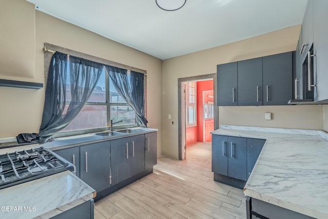 2712 Federal Ave, El Paso, TX 79930 - kitchen featuring a sink, light countertops, light wood-style floors, and gas stove