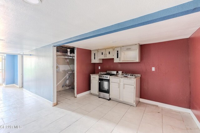 2712 Federal Ave, El Paso, TX 79930 - kitchen featuring gas stove, baseboards, white cabinetry, a textured ceiling, and light countertops