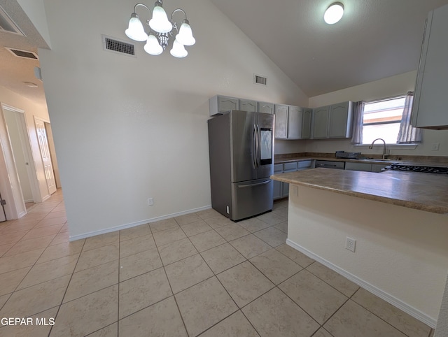 11740 Autumn Wheat Dr, El Paso, TX 79934 - kitchen featuring stainless steel fridge, a peninsula, high vaulted ceiling, light tile patterned flooring, and a chandelier