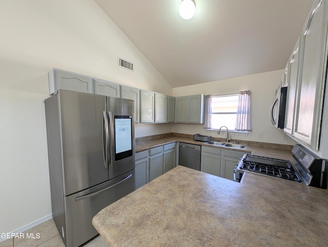 11740 Autumn Wheat Dr, El Paso, TX 79934 - kitchen with appliances with stainless steel finishes, a sink, vaulted ceiling, a peninsula, and gray cabinetry