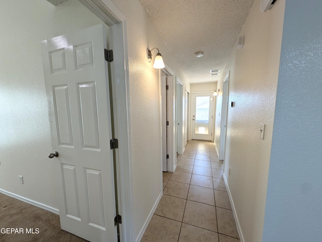 11740 Autumn Wheat Dr, El Paso, TX 79934 - corridor featuring a textured ceiling, light tile patterned floors, baseboards, and a textured wall