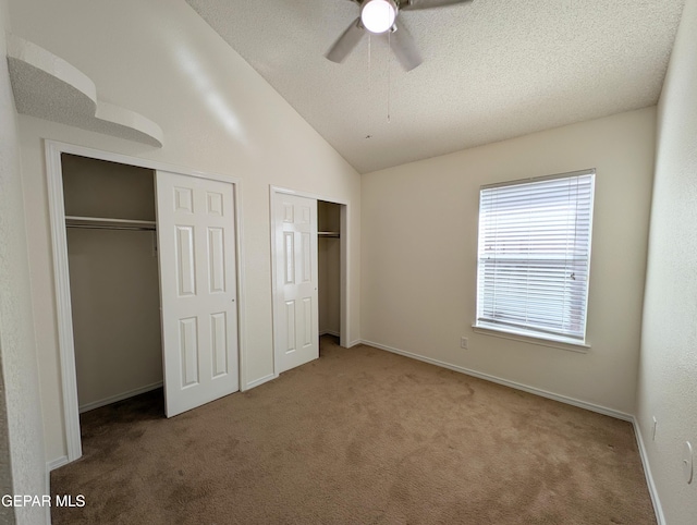 11740 Autumn Wheat Dr, El Paso, TX 79934 - unfurnished bedroom with two closets, carpet flooring, a textured ceiling, lofted ceiling, and ceiling fan