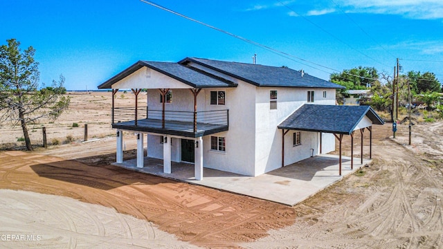 13090 Socorro Rd, San Elizario, TX 79849 - rear view of property featuring a balcony, stucco siding, a patio area, and a carport