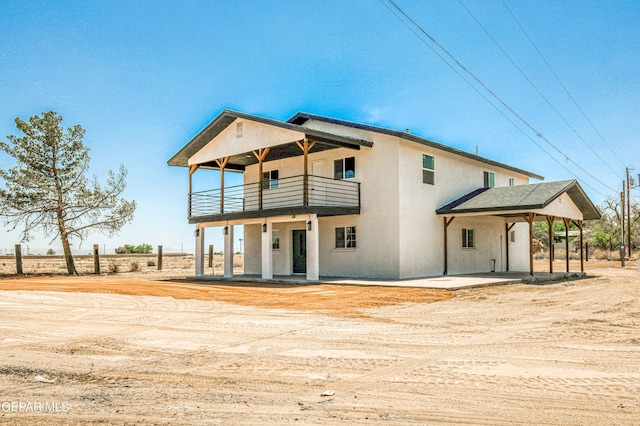 13090 Socorro Rd, San Elizario, TX 79849 - rear view of property featuring a balcony, stucco siding, and driveway