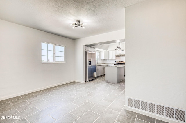 13090 Socorro Rd, San Elizario, TX 79849 - kitchen with stainless steel appliances, light countertops, a sink, baseboards, and a textured ceiling