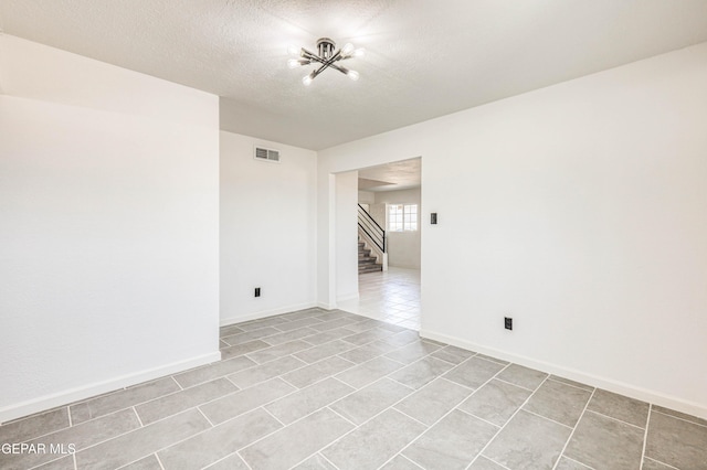 13090 Socorro Rd, San Elizario, TX 79849 - spare room featuring stairs, light tile patterned floors, baseboards, and a textured ceiling