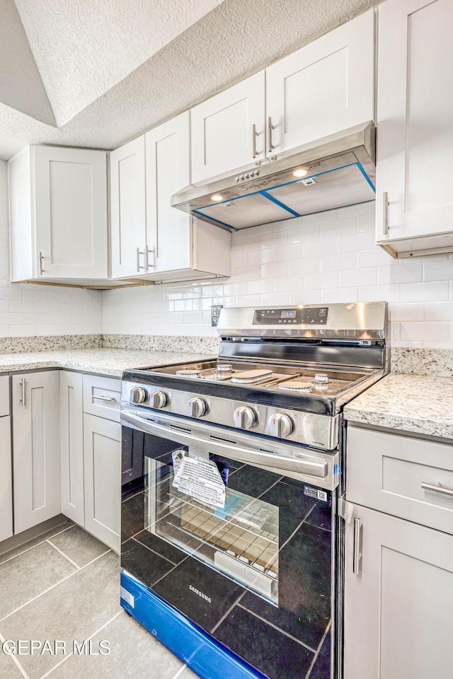 13090 Socorro Rd, San Elizario, TX 79849 - kitchen featuring electric stove, exhaust hood, tasteful backsplash, white cabinetry, and a textured ceiling
