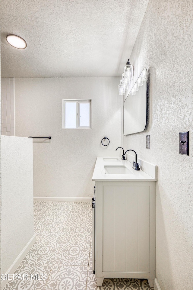 13090 Socorro Rd, San Elizario, TX 79849 - bathroom with vanity, a textured ceiling, and baseboards