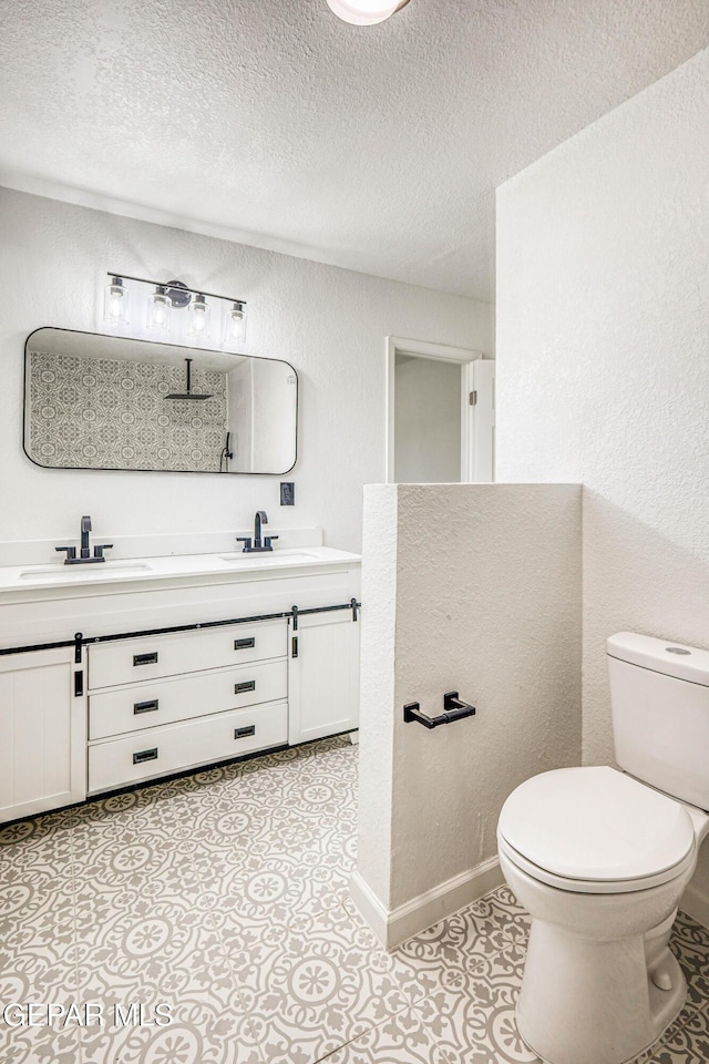 13090 Socorro Rd, San Elizario, TX 79849 - full bathroom with toilet, double vanity, a textured ceiling, and a textured wall