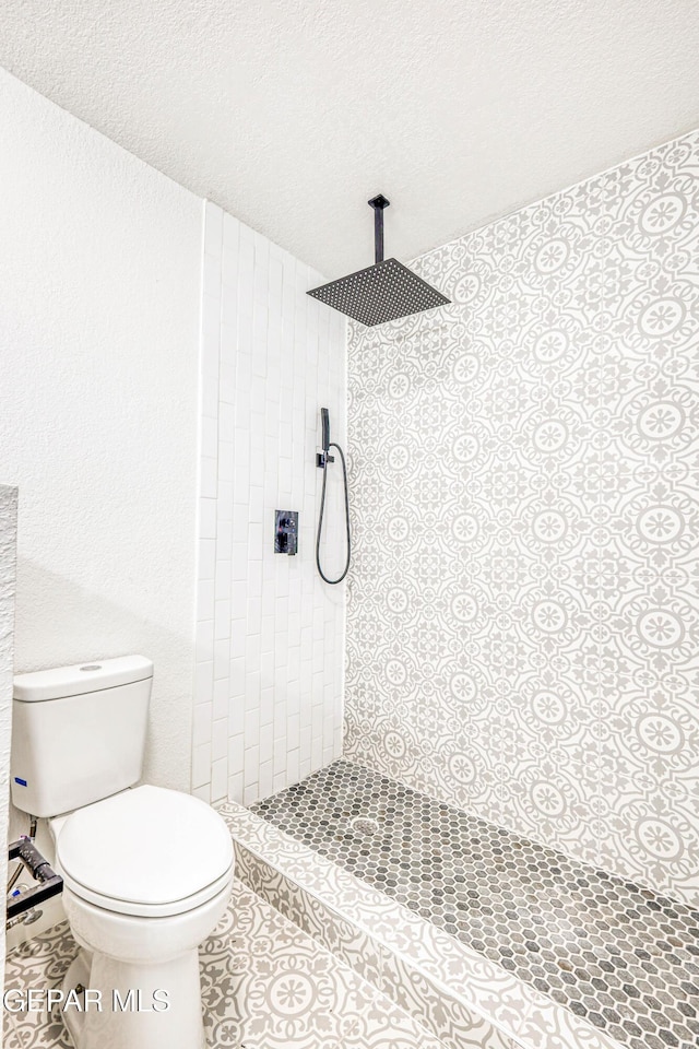 13090 Socorro Rd, San Elizario, TX 79849 - full bath featuring tiled shower, toilet, a textured ceiling, a textured wall, and tile patterned floors