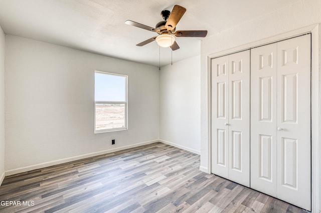 13090 Socorro Rd, San Elizario, TX 79849 - unfurnished bedroom with wood finished floors, a closet, baseboards, and ceiling fan