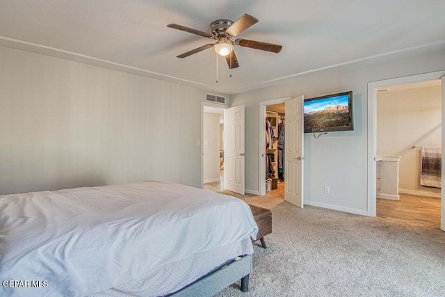 6504 Camino Fuente Dr, El Paso, TX 79912 - bedroom with a walk in closet, light colored carpet, baseboards, a ceiling fan, and ensuite bath