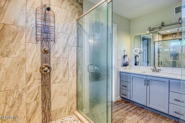 6504 Camino Fuente Dr, El Paso, TX 79912 - bathroom featuring a shower stall, vanity, and wood finished floors
