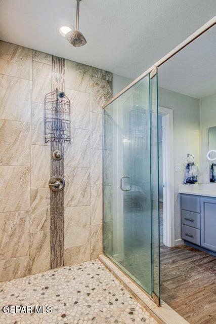 6504 Camino Fuente Dr, El Paso, TX 79912 - full bath featuring a shower stall, vanity, and wood finished floors