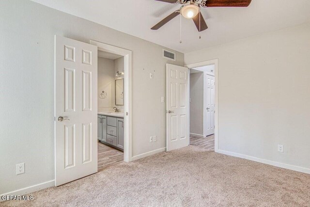 6504 Camino Fuente Dr, El Paso, TX 79912 - unfurnished bedroom with light colored carpet, a sink, baseboards, ensuite bathroom, and a ceiling fan