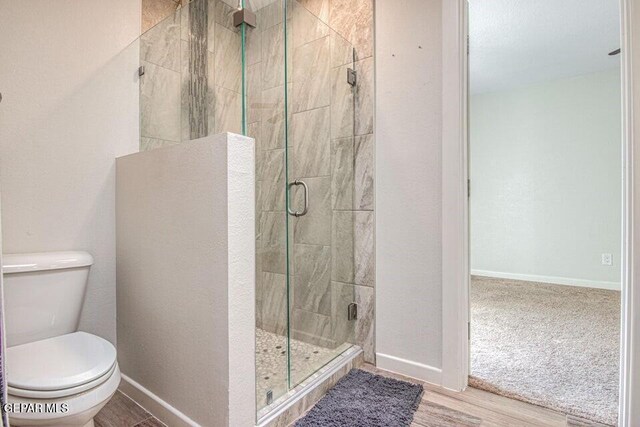 6504 Camino Fuente Dr, El Paso, TX 79912 - bathroom featuring toilet, a shower stall, baseboards, and wood finished floors