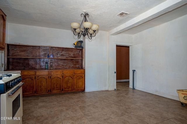 363 Ontiveros St, El Paso, TX 79932 - kitchen featuring white gas range, a chandelier, a textured ceiling, and brown cabinets