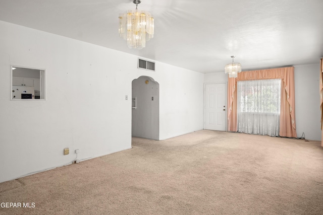 1611 N Kansas St, El Paso, TX 79902 - spare room with a chandelier, carpet flooring, and arched walkways