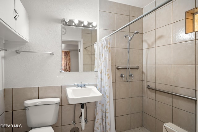 1611 N Kansas St, El Paso, TX 79902 - bathroom with tile walls, toilet, a shower stall, and a sink
