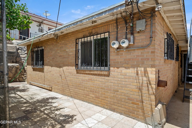 1611 N Kansas St, El Paso, TX 79902 - view of side of home with brick siding and a patio area