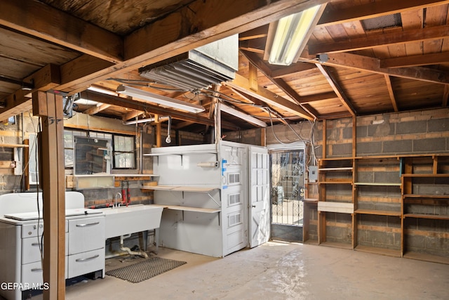 1611 N Kansas St, El Paso, TX 79902 - below grade area featuring washer / dryer, a sink, concrete block wall, and a workshop area