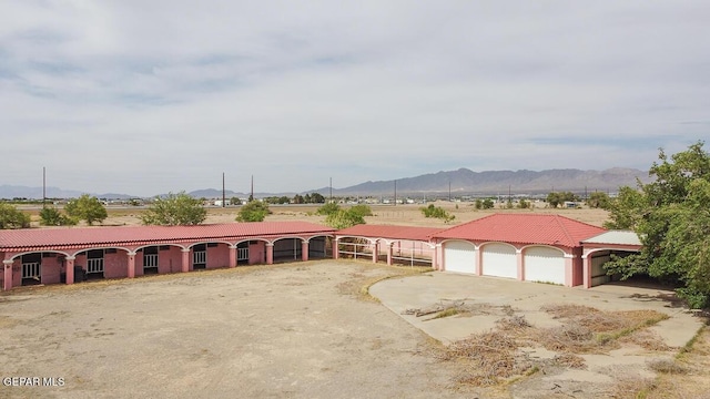 6100 Valley Dr, El Paso, TX 79932 - view of front of home with driveway, an attached garage, a mountain view, a tile roof, and stucco siding