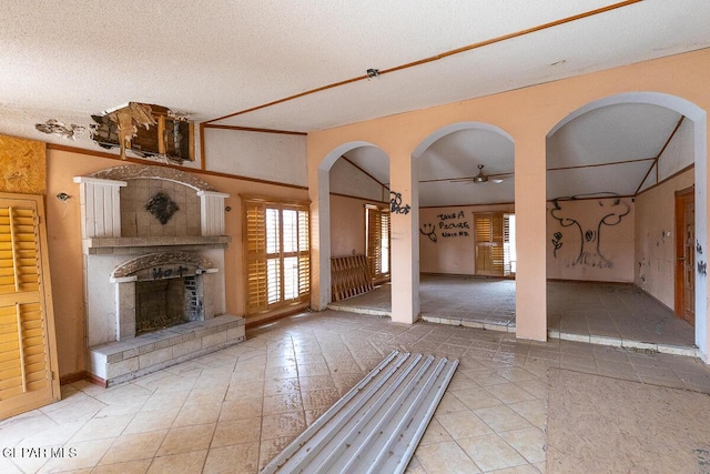 6100 Valley Dr, El Paso, TX 79932 - unfurnished living room featuring a ceiling fan, a fireplace with raised hearth, a textured ceiling, and tile patterned floors