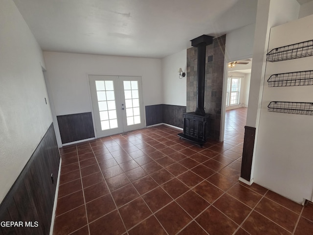 5121 Juliandra Ave, El Paso, TX 79924 - unfurnished living room with a wood stove, dark tile patterned floors, french doors, and wainscoting