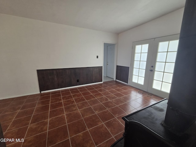 5121 Juliandra Ave, El Paso, TX 79924 - spare room with french doors, dark tile patterned flooring, wainscoting, and lofted ceiling